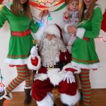 Santa with cheerful elves and child